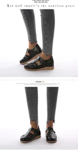 Detail view of black hollow-out wedge sandals with velcro strap and thick textured sole
