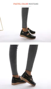 Close-up of black hollow-out mother shoes with wedge soles and velcro straps
