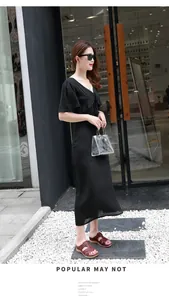 Robe midi noire à col en V tendance avec sandales compensées marron et sac transparent