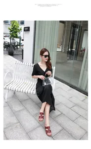 Sandales plates en cuir marron à découpe H portées avec robe noire et sac transparent