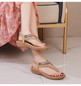Detail von beigen Perlensandalen mit elastischem Band und Keilsohle am Modell