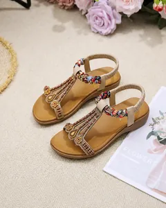 Detail of bohemian flat sandals featuring intricate beadwork and golden floral accents