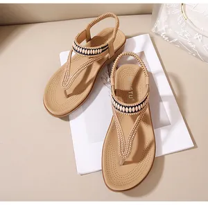 Detail der verzierten T-Riemen Sandale mit elastischer Ferse und beige Innensohle