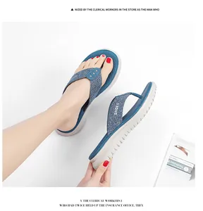 Detail view of navy fabric flip-flops featuring metal studs and cushioned wedge soles