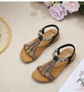 Detail of bohemian flat sandals with black beaded floral T-strap and elastic heel strap