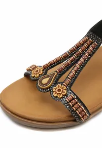 Close-up of women's sandals featuring vintage floral beads and sparkling rhinestones