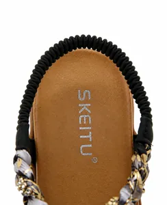 Detail shot of summer sandal featuring brown leather insole and black elastic heel strap