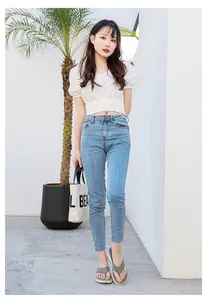 Outdoor shot of stylish grey flip flops paired with skinny jeans and white crop top