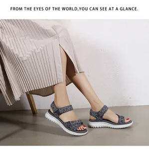 Close-up of women's gray fabric sports sandal with velcro strap and white platform sole