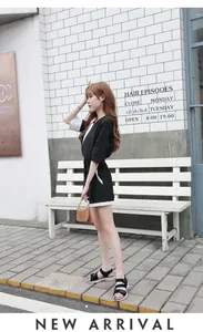 Detail view of a black romper with white contrast piping and professional waist cut design