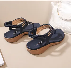Detailansicht der dunkelblauen Perlentragriemen-Sandalen mit elastischem Riemen und Keilsohle