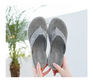 Detail of grey flip flops with glitter straps and three silver metal rivets on outdoor background