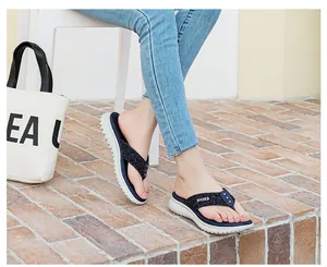 Detail of wedge flip flops with blue woven straps and non-slip white rippled sole