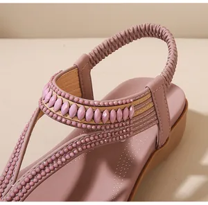 Makro-Detail des Bohème-Perlenobermateriaals und des Gummibands der Keilsandalen