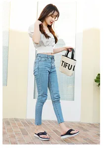 Outdoor shot of stylish navy platform thong sandals worn with jeans on red brick pavement