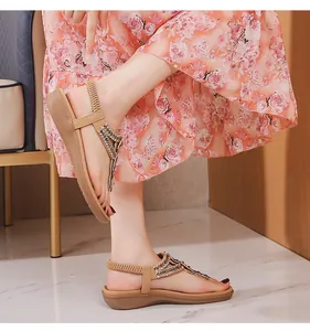 Détail de la bride en T avec strass sur des sandales compensées confortables pour l'été