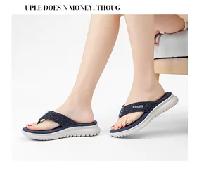 Close-up of navy blue flip flops with 'SHOES' text on fabric straps and foam sole