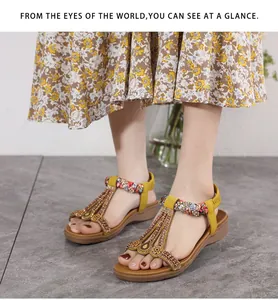 Detail of bohemian yellow sandals with colorful beads and braided straps on feet