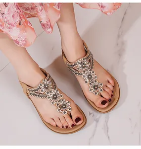 Détail de fleurs en strass sur des sandales compensées bohèmes avec bride élastique