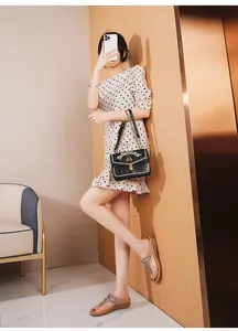 Sandalias de mujer con pedrería combinadas con un vestido de lunares y bolso de cadena