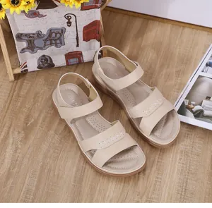 Détail de sandales compensées beige avec coutures en croix et semelle respirante