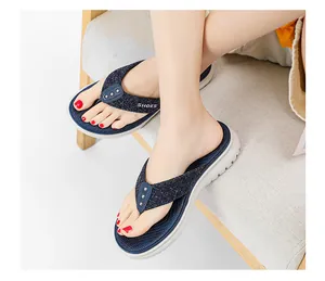 Close-up of navy flip-flops featuring silver studs and a white platform sole