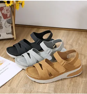 Tre paia di sandali leggeri con plateau in nero, grigio e cammello su legno