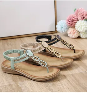 Detailed view of bohemian flip-flop sandals with woven straps and colorful bead embellishments