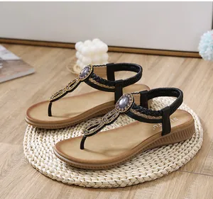 Detail of bohemian flat sandals featuring ethnic rhinestones and gold braided trim