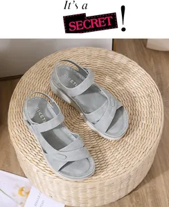 Top view of grey platform sandals with fabric straps and stitching detail on woven background
