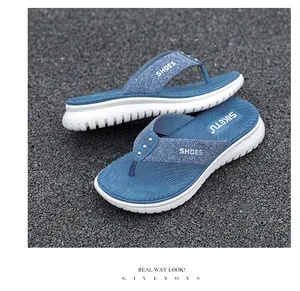 Detail of blue thong sandals with metallic studs and thick white non-slip soles