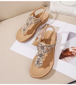 Détail de fleurs en strass et perles sur sandales compensées avec bride élastique