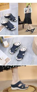 Dettaglio dei sandali con zeppa blu navy con cinturini incrociati e fibbie argentate