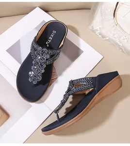 Detalle de flores de cuentas y suela de cuña suave en las sandalias de plataforma
