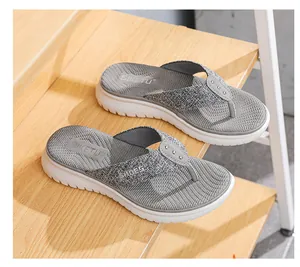 Detail of grey fabric thong straps with metal studs and platform sole on wooden steps
