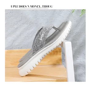Detail of gray flip-flops featuring thick white platform soles and SHOES logo text