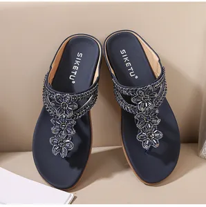 Vista superior de chanclas azul marino con exquisitas flores de pedrería y cuentas