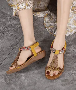 Detail of yellow bohemian wedge sandals with colorful beads, rhinestones and T-strap
