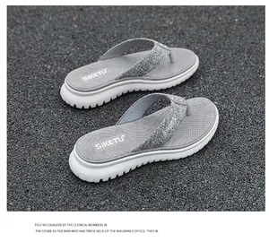 Close-up of dark grey platform flip flops with glitter straps and non-slip textured footbed