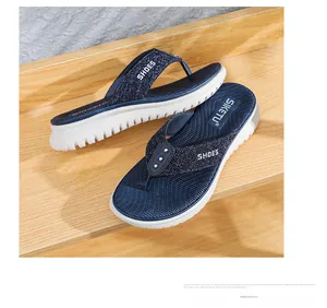 Detail showing the thick non-slip wedge sole and navy thong straps with silver studs