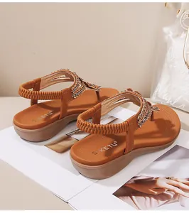 Détail de sandales compensées bohèmes avec strass brillants et perles artisanales