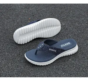 Detail view of denim flip flops showing non-slip wedge soles and metallic studs
