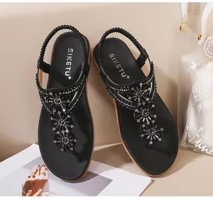 Détail de sandales noires d'été avec perles en strass fleuries et bride arrière élastique