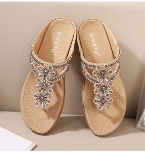 Primer plano de flores de strass y plantillas transpirables en sandalias planas