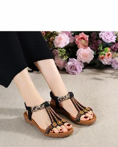 Close-up of bohemian beaded sandals with floral charms and brown cushioned soles