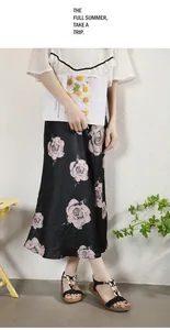 Détail d'une jupe mi-longue évasée avec base en soie noire et motif floral de roses