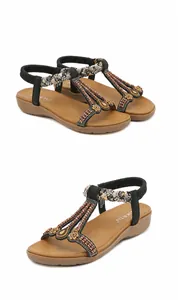 Detail of ethnic sandals with beaded floral straps and elastic back on padded brown sole