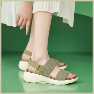 Close-up of olive green platform sandals with elastic knit straps and chunky white sole