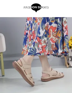 Détail de sandales compensées beige à velcro portées avec une robe à fleurs chic