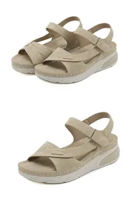 Detail view of beige wedge sandals featuring adjustable velcro straps and white contrast stitching